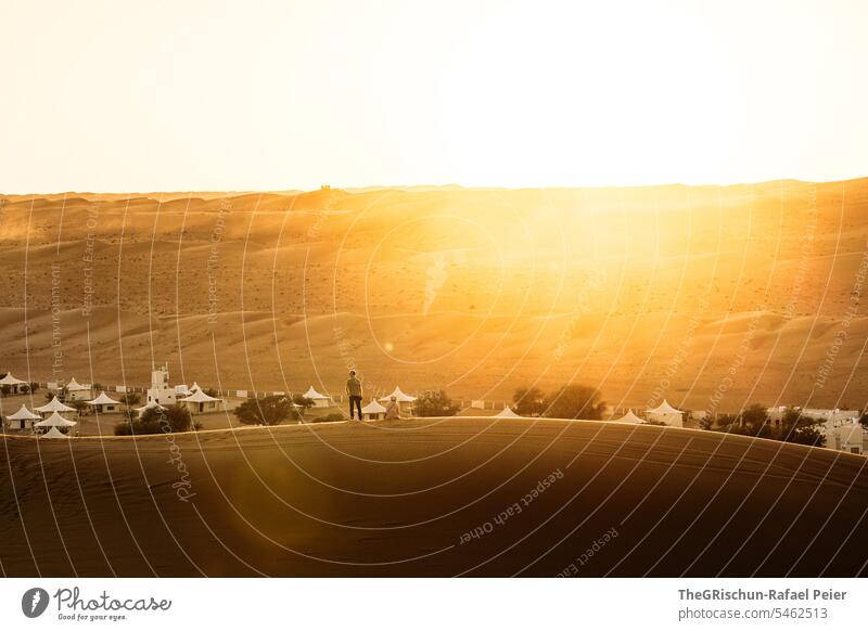 Mann Steht auf Düne in der Wüste und geniesst die letzten Sonnenstrahlen Sonnenlicht Gegenlicht Sand Sonnenuntergang Außenaufnahme Farbfoto Natur Abend Wasser