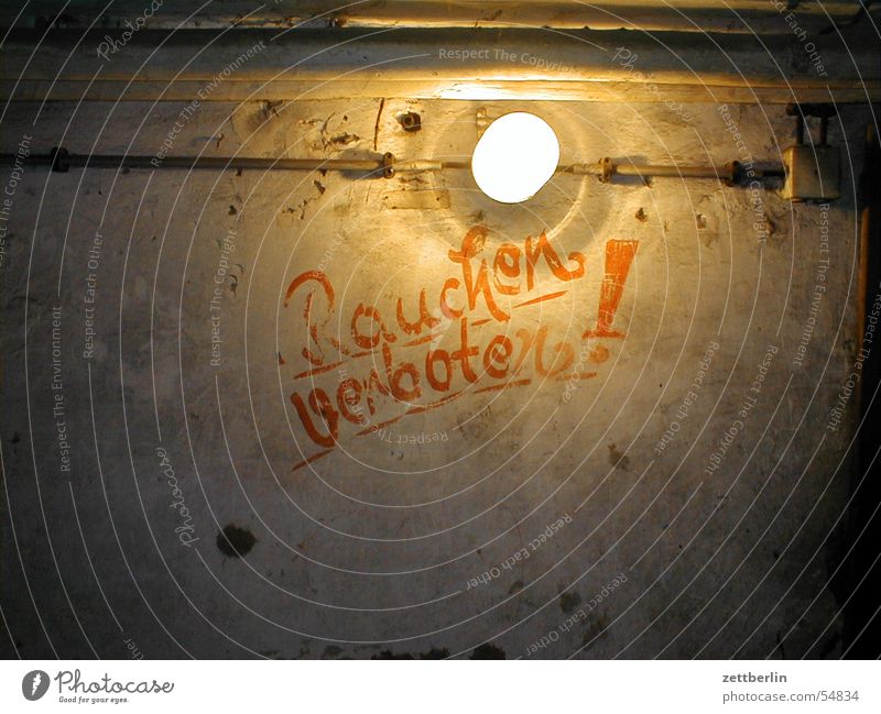 Rauchen verboten! Keller unterirdisch Bunker Glühbirne grell Verbote Nichtraucher dunkel braun Innenaufnahme verfallen Text Lateinische Schrift Hinweisschild