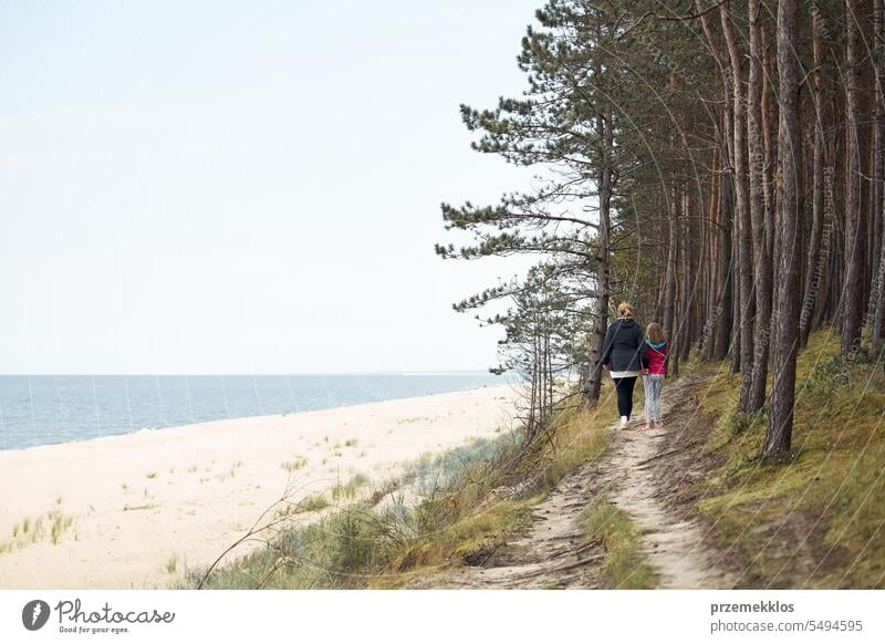 Frau und ihre Tochter gehen am Meer und im Wald spazieren. Familie macht Urlaub am Meer. Sommerreise. Genießen Sie die freie Zeit Ferien Ausflug MEER laufen