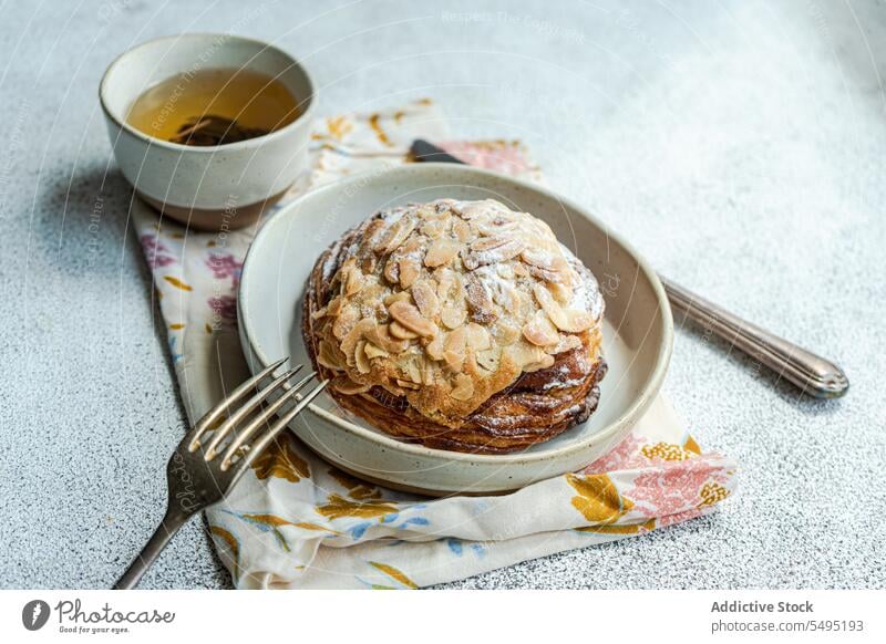 Süßes Mandelgebäck auf dem Teller mit einer Tasse grünem Tee süß Gebäck Speise Oberfläche Tisch hoher Winkel von oben Lebensmittel trinken Dessert essen lecker