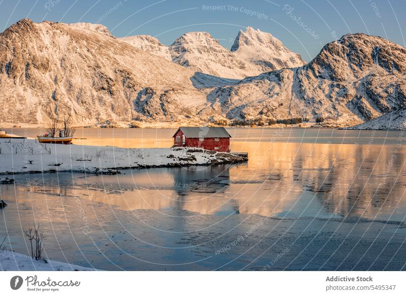 Haus am Ufer in der Nähe von Wasser gegen Berge im Winter Landschaft Berge u. Gebirge Kamm MEER Formation Cottage felsig Schnee kalt frieren Meeresufer lofoten