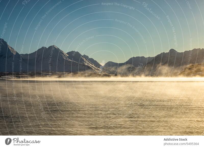 Erstaunliche Aussicht auf schneebedeckte Berge mit Meerwasser unter wolkenlosem blauem Himmel erstaunlich Berge u. Gebirge Ambitus MEER Schnee Landschaft Winter