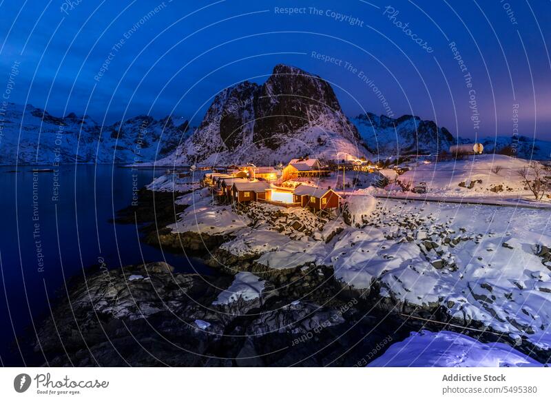 Häuser in Meeresnähe in einem Gebirgstal im Winterabend Landschaft Berge u. Gebirge Kamm MEER Formation Haus Abend felsig Küste Cottage Ufer Schnee kalt frieren