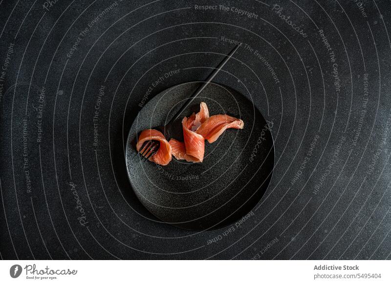 Gesunder Lachs in Scheiben auf dunklem Teller Speise Gesundheit Lebensmittel schwarz dunkel Vor dunklem Hintergrund Tisch Oberfläche lecker frisch Ernährung