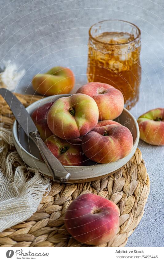 Pfirsichsorte Zodiac und Sommerlimonade mit Eis Tierkreis Varieté Limonade Glas Messer Serviette Unschärfe verschwommener Hintergrund Teller Speise Geschirr