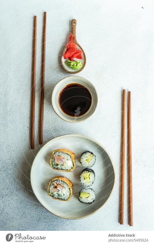 Draufsicht auf japanisches Essen auf einem weißen Betontisch dienen Kulisse Sushi rollen Schalen & Schüsseln Lachs Reis Seegras Sojasauce Asiatische Küche