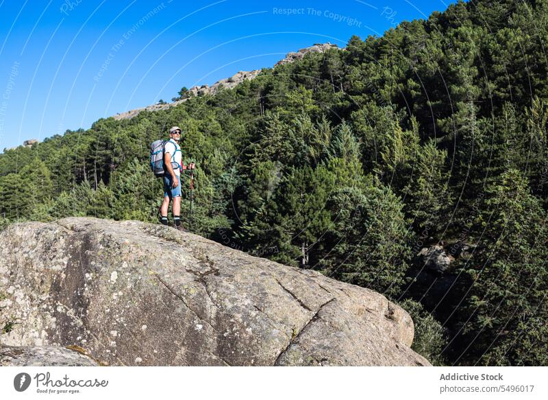 Reisender steht auf rauer Klippe Mann Wanderer Saum Natur bewundern Wanderung felsig Abenteuer männlich Rucksack kleben reisen Ausflug Felsen Sommer erkunden