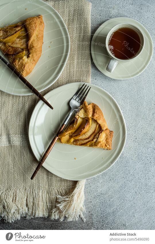 Apfelgalette und Tee auf dem modernen Betontisch Pasteten Spielfigur Galette Tasse Teetasse rustikal grau Tisch Lebensmittel trinken Getränk liquide heiß