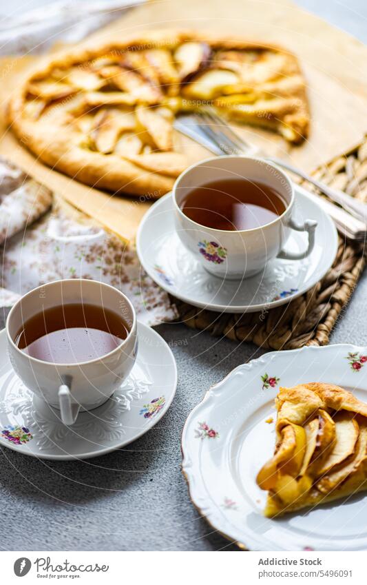 Apfelgalette und Tee auf dem modernen Betontisch Pasteten Spielfigur Galette Tasse Teetasse rustikal Tablett grau Tisch Lebensmittel trinken Getränk liquide