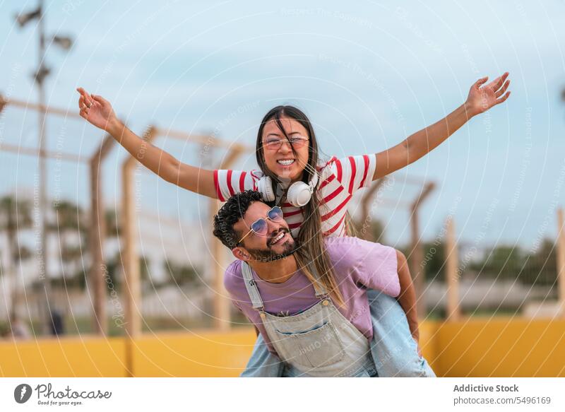 Freunde, die Huckepack nehmen und lächeln Paar Umarmung Straße Glück Lächeln Liebe Partnerschaft Sonnenbrille romantisch Termin & Datum Zusammensein Umarmen