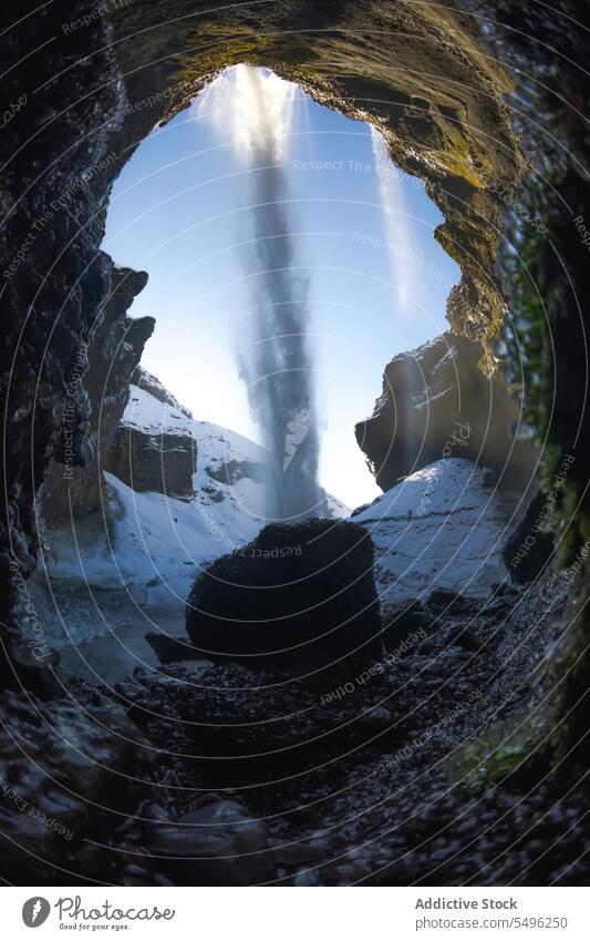 Erstaunliche Wasserfall in verschneiten Bergen gegen blauen Himmel im Tageslicht malerisch Landschaft Berge u. Gebirge Klippe felsig Natur fließen Schnee