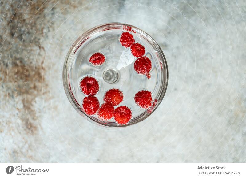 Glas Champagner und Himbeer-Cocktail gegen unscharfen Hintergrund frisch Himbeeren trinken Alkohol Erfrischung dienen Getränk reif Beeren Tisch kalt Vitamin