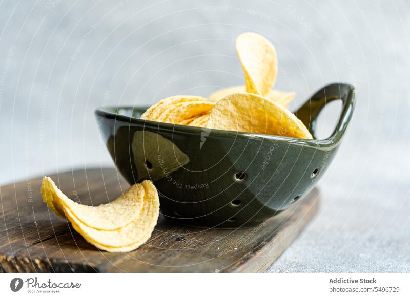 Schüssel mit Stücken von knusprigen Kartoffelchips auf dem Tisch Chip Schalen & Schüsseln lecker Spielfigur Snack Fastfood Knusprig knirschen Lebensmittel