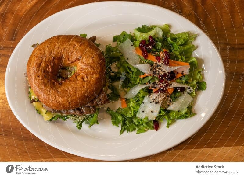 Leckerer Burger mit Rindfleisch, Käse und grünem Gemüse auf einem Teller in hellem Möhre Hamburger Salat Fleisch geschmackvoll lecker Fastfood Mahlzeit Speise