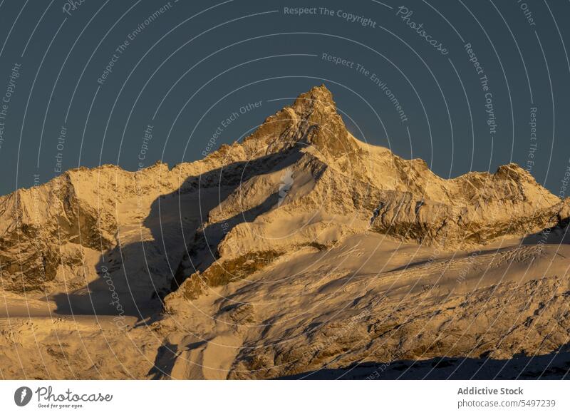 Verschneite Berge an einem Wintertag unter dunklem Himmel bei Sonnenaufgang Berge u. Gebirge Landschaft Schnee Natur felsig Gipfel malerisch Kamm kalt