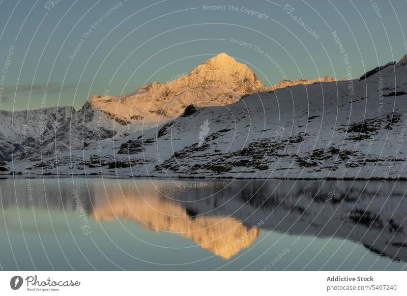 Schneebedeckte Berge im Winter Tag in der Nähe von See unter dunklen Himmel bei Sonnenaufgang Berge u. Gebirge Landschaft Natur felsig Gipfel malerisch Kamm