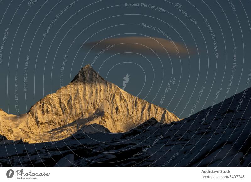 Verschneite Berge an einem Wintertag unter dunklem Himmel bei Sonnenaufgang Berge u. Gebirge Landschaft Schnee Natur felsig Gipfel malerisch Kamm kalt