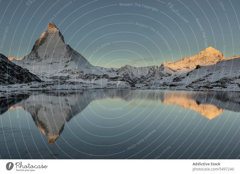 Schneebedeckte Berge im Winter Tag in der Nähe von See unter dunklen Himmel bei Sonnenaufgang Berge u. Gebirge Landschaft Natur felsig Gipfel malerisch Kamm