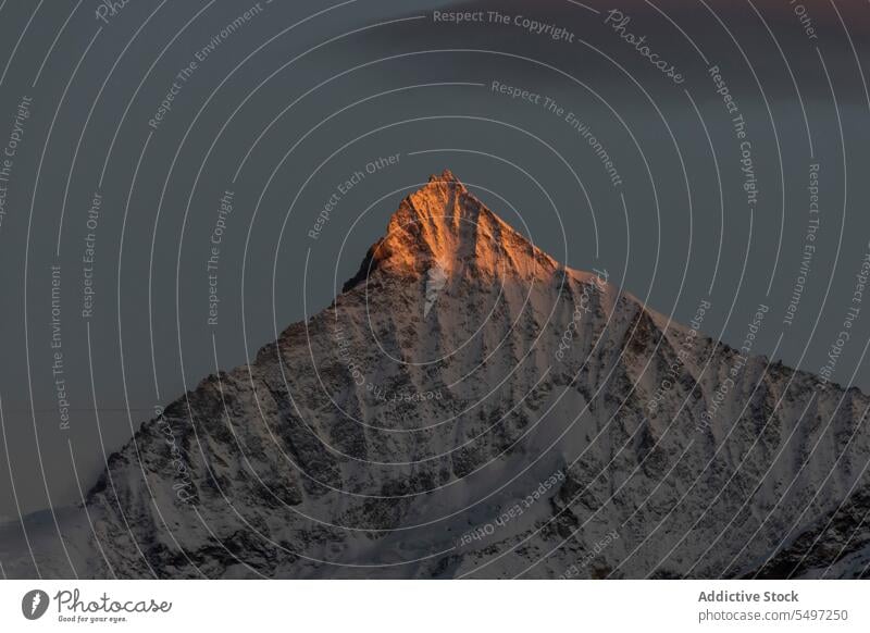 Verschneite Berge an einem Wintertag unter dunklem Himmel bei Sonnenaufgang Berge u. Gebirge Landschaft Schnee Natur felsig Gipfel malerisch Kamm kalt