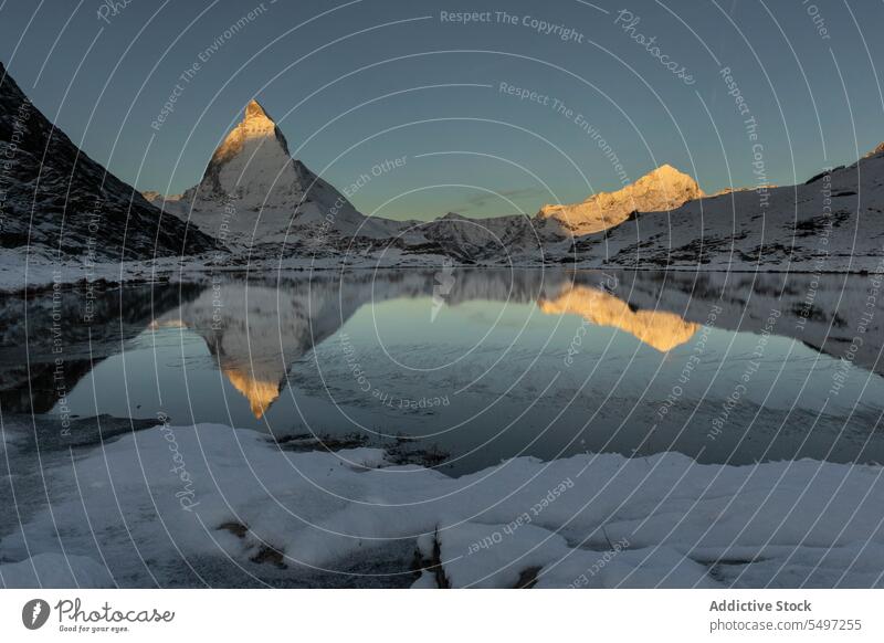 Schneebedeckte Berge im Winter Tag in der Nähe von See unter dunklen Himmel bei Sonnenaufgang Berge u. Gebirge Landschaft Natur felsig Gipfel malerisch Kamm