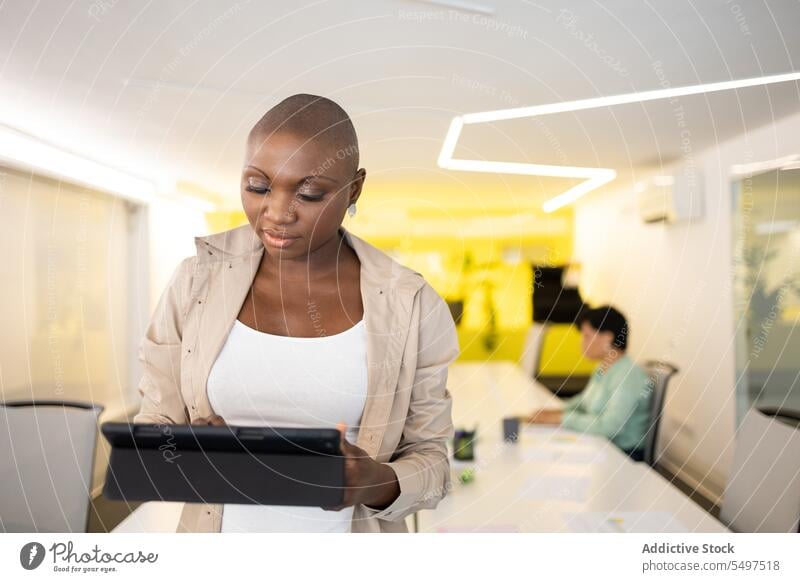 Seriöse Frau mit Tablet im Büro Tablette Arbeit positiv Optimist professionell Apparatur Gerät modern Job Internet Arbeitsplatz angenehm Anschluss zufrieden