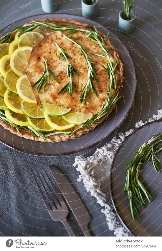 Zitronenkuchen, belegt mit Zitronenscheiben und Rosmarinblättern Pasteten Gebäck selbstgemacht Küche traditionelles Rezept handgefertigt Leckerbissen Herbst