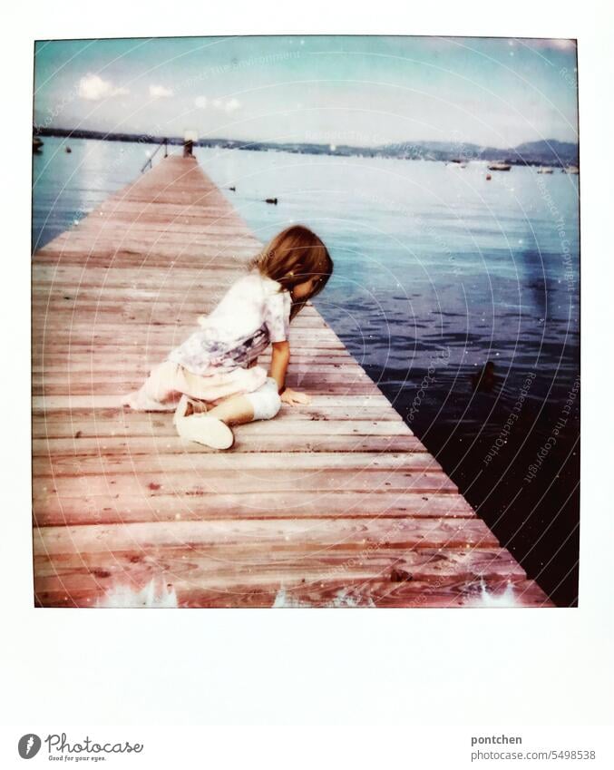 polaroid. ein mädchen sitzt auf einem steg und blickt auf das wasser im gardasee holzsteg Gardasee Steg Wasser urlaub Polaroid Sommer reisen