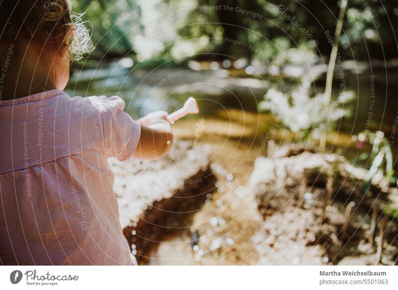 Kind spielt in Bach mit Sand und Kies Sandspiel Spielen im Freien spielen in der natur Spielen im Bach Natur Spielen mit Wasser Im Freien Sommer auf dem Land