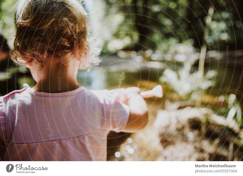 Kind spielt in Bach mit Sand und Kies Sandspiel Spielen im Freien spielen in der natur Spielen im Bach Natur Spielen mit Wasser Im Freien Sommer auf dem Land