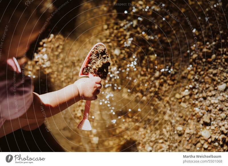 Kind spielt in Bach mit Sand und Kies Sandspiel Spielen im Freien spielen in der natur Spielen im Bach Natur Spielen mit Wasser Im Freien Sommer auf dem Land