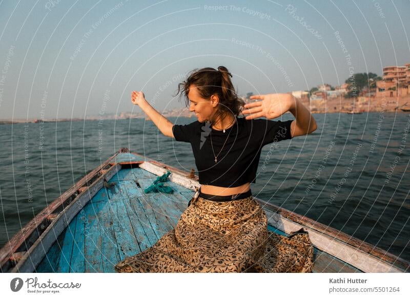 eine junge Frau sitz au einem Holzboot in Varanasi Boot fahren Wasser Wasserfahrzeug Ferien & Urlaub & Reisen Schifffahrt Farbfoto Außenaufnahme Tourismus