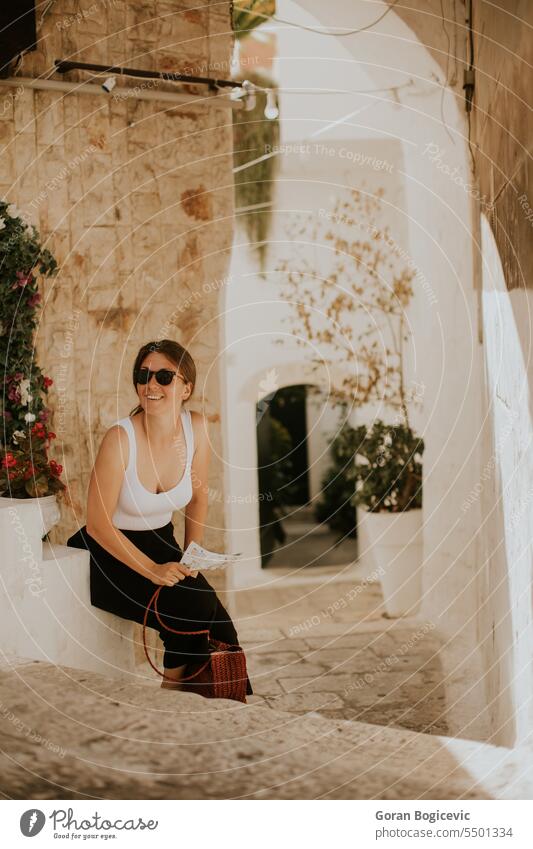 Touristin mit Papierstadtplan in den engen Straßen von Ostuni, Italien Gasse antik Apulien architektonisch Architektur Gebäude Zentrum Großstadt Ausflugsziel