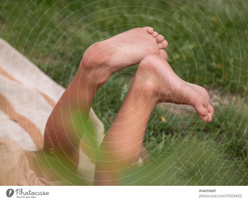 Kinderfüße im Gras unge liegend Kinderfüsse zehen kleinkind spielen kindheit glückliche Kindheit lausebengel lausbuben gras natur draußen draussen outdoor