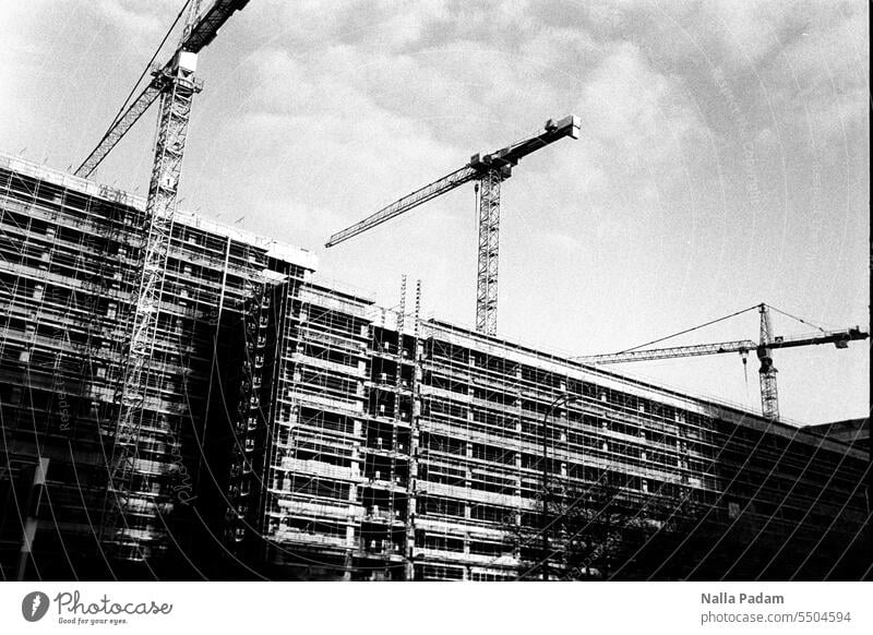 Kräne auf Baustelle - seitlich analog Analogfoto sw Schwarzweißfoto schwarzweiß Architektur Gebäude Kran Gerüst Sanierung Außenaufnahme Stellung Umbau Haus