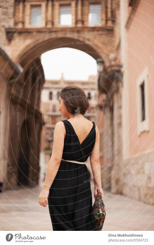 Schöne Frau von hinten im kleinen schwarzen Kleid auf der Straße der historischen Stadt. Wunderschönes Mädchen Sightseeing in Europa. Selbstbewusste Frau, Solo weiblichen Reisenden. Glamour und chic, Mode und Stil-Konzept.