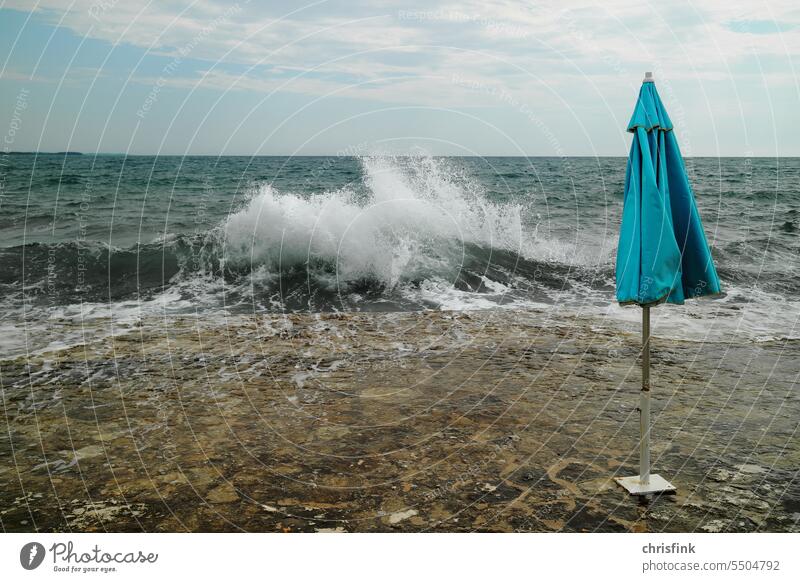 Sonnenschirm an Strandbad mit starkem Seegang strand sonnenschirm wellen Brandung Meer WellenWasser Sand Ferien & Urlaub & Reisen Horizont Außenaufnahme Küste