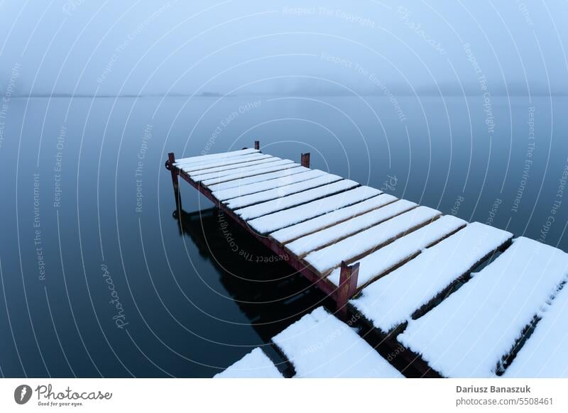 Schneebedeckter Steg am See an einem nebligen Tag Nebel Pier blau Wetter Natur Himmel Wasser Hintergrund Saison Winter weiß kalt Landschaft Ansicht Frost