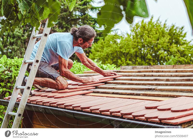 Dachsanierung Gartenhaus. Dachdecker bei der Arbeit, Dach decken mit Tonziegel Schuppen Sommerhaus Nebengebäude Holz neu Ziegel Aktiv Senior Architektur Bau