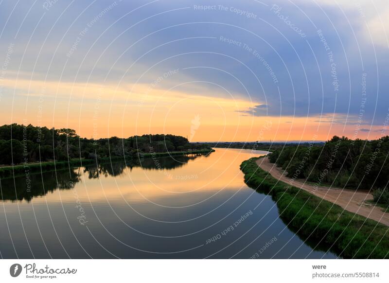 Farbenfroher Sonnenuntergang über dem Wasser des Canal du Rhone bei Aigues-Mortes in Carmarque camarque Canal du Midi Rhône-Kanal bei Sète Frankreich