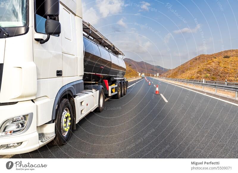 Ein liegengebliebener Tanklastzug auf der Autobahn mit von der Autobahnmeisterei aufgestellten Leitkegeln, um die verkehrsreiche Fahrbahn abzusperren. Lastwagen