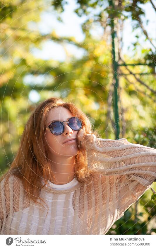 Porträt einer jungen schönen Frau mit Sonnenbrille. Hübsches rothaariges Mädchen mit roten Haaren. Park Lächeln Glück hübsch rote Haare heiter attraktiv