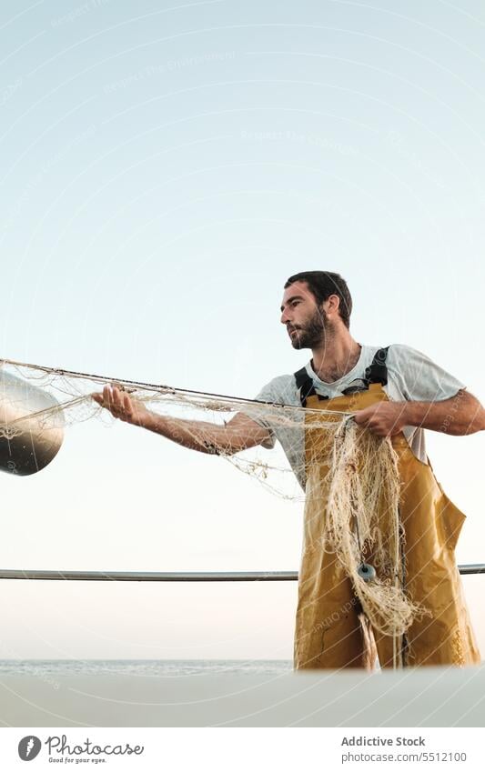 Fischer, der vom Segelboot aus im offenen Meer fischt Boot MEER Fischen Netz Schoner Arbeit Uniform männlich Soller Balearen Mallorca Wadenfisch jagen Trawler