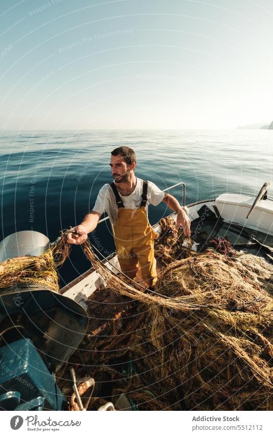 Fischer, der vom Segelboot aus im offenen Meer fischt Boot MEER Fischen Netz Schoner Arbeit Uniform Fokus männlich Soller Balearen Mallorca Wadenfisch jagen