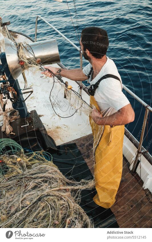 Fischer, der vom Segelboot aus im offenen Meer fischt Boot MEER Fischen Netz Schoner Arbeit Uniform Fokus männlich Soller Balearen Mallorca Wadenfisch jagen