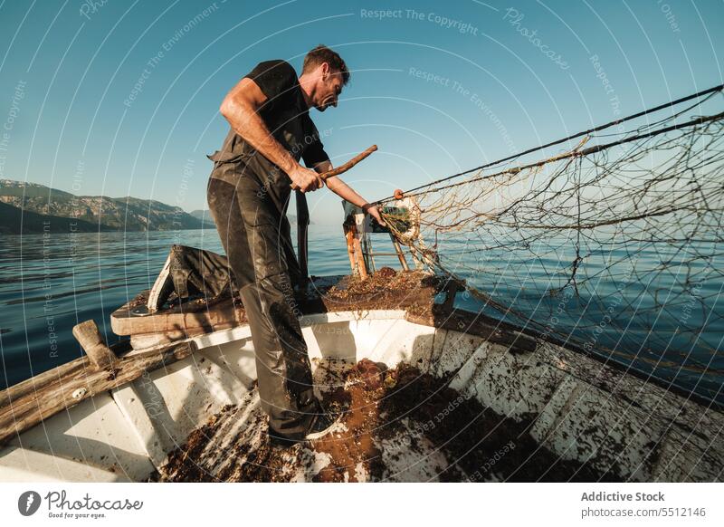 Fischer, der vom Segelboot aus im offenen Meer fischt Boot MEER Fischen Netz Schoner Arbeit Uniform männlich Soller Balearen Mallorca Wadenfisch jagen Trawler