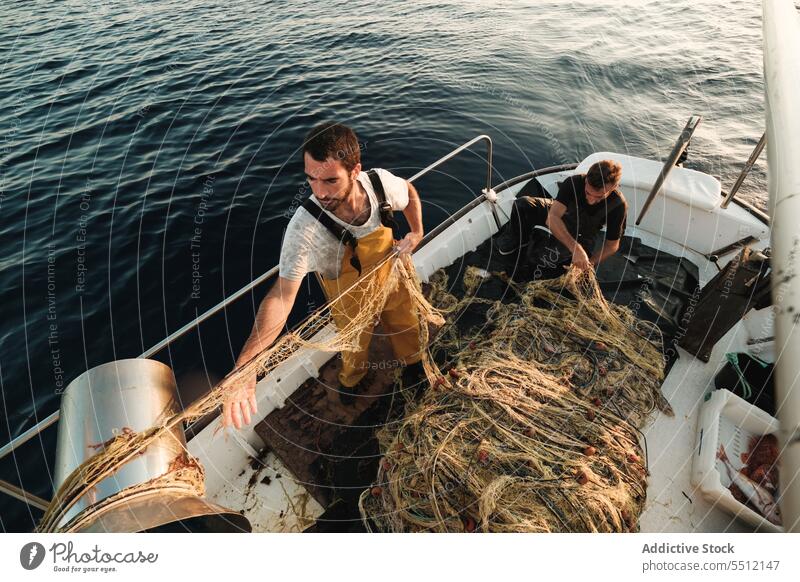 Fischer, der vom Segelboot aus im offenen Meer fischt Boot MEER Fischen Netz Schoner Arbeit Uniform Fokus männlich Soller Balearen Mallorca Wadenfisch jagen