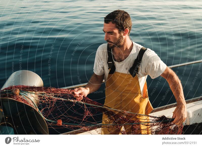 Fischer, der vom Segelboot aus im offenen Meer fischt Boot MEER Fischen Netz Schoner Arbeit Uniform Fokus männlich Soller Balearen Mallorca Wadenfisch jagen