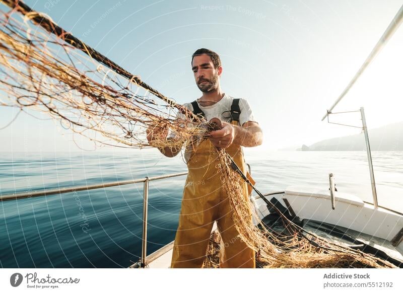 Fischer, der vom Segelboot aus im offenen Meer fischt Boot MEER Fischen Netz Schoner Arbeit Uniform männlich Soller Balearen Mallorca Wadenfisch jagen Trawler