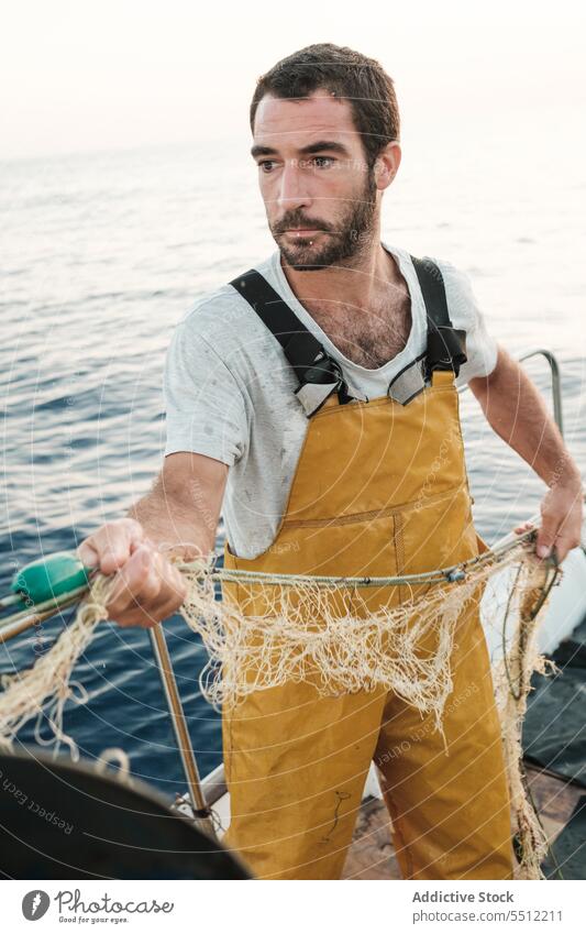 Fischer, der vom Segelboot aus im offenen Meer fischt Boot MEER Fischen Netz Schoner Arbeit Uniform Fokus männlich Soller Balearen Mallorca Wadenfisch jagen