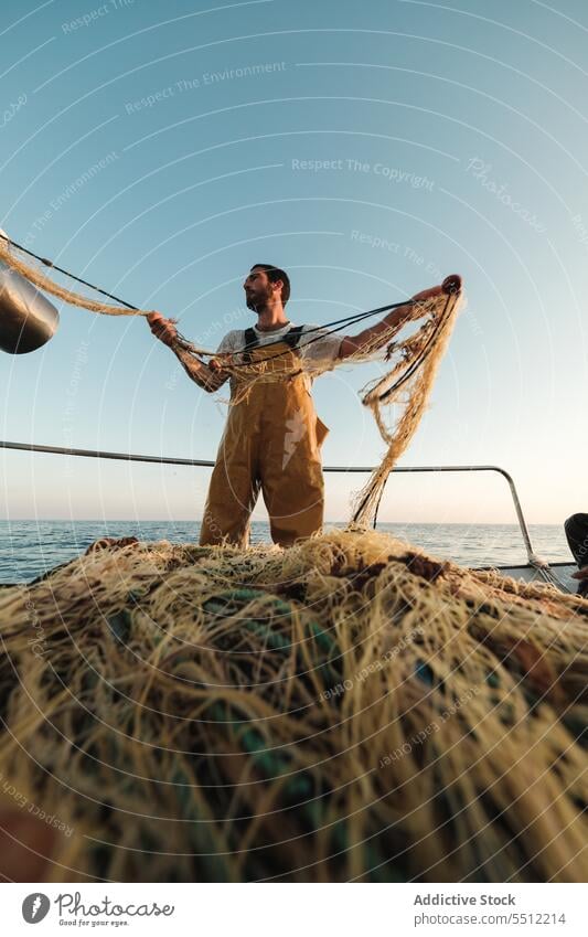 Fischer, der vom Segelboot aus im offenen Meer fischt Boot MEER Fischen Netz Schoner Arbeit Uniform männlich Soller Balearen Mallorca Wadenfisch jagen Trawler